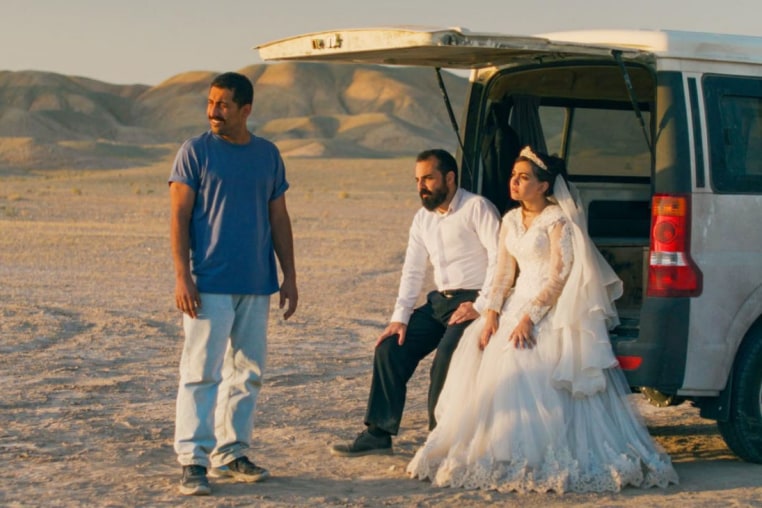 From left, Mohamad Ali Elyasmehr as Hamid, Majid Panahi as Ali, Hadis Pakbaten as Goli sit outside near a car