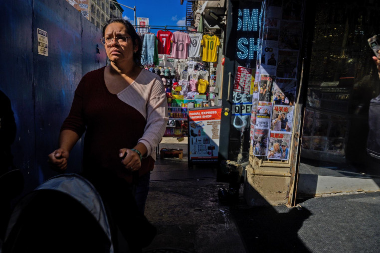 A woman pushes a stroller Wednesday on Canal Street, the day after an immigration raid in the area.