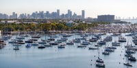 A drone view shows sailboats moored next to the Coconut Grove Sailing Club and the downtown skyline in Miami