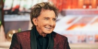 Barry Manilow smiles while seated