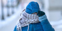Yahaira Rojas, of Milwaukee, shields her face from the cold as she walks down North 10th Street in from of the Milwaukee County Courthouse in Milwaukee, Wisconsin on Jan. 23, 2026. 