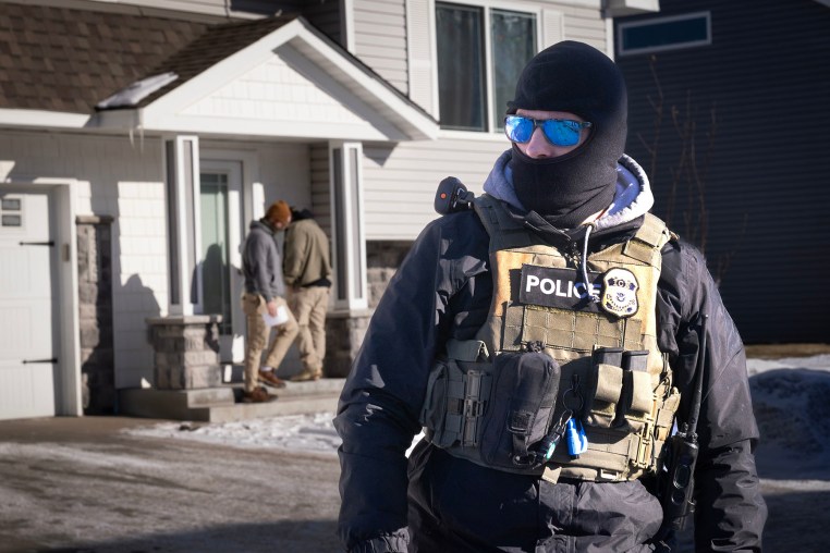 ICE agents look for someone at a home on Jan. 28, 2026 in Circle Pines, Minnesota.
