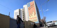 An Iranian walks past a huge anti-US mural painted on the side of a building in the Iranian capital Tehran on January 31, ahead of the 47th anniversary of the 1979 Islamic Revolution.