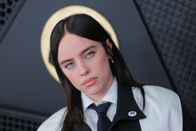 Billie Eilish wearing an "ICE OUT" pin on the GRAMMYs red carpet.