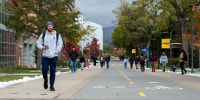 Students walk through campus down a street