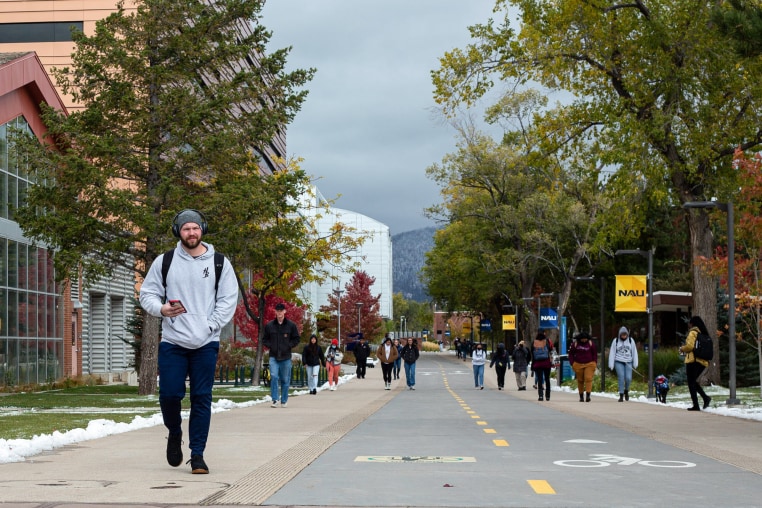 Students walk through campus down a street