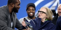 SEATTLE, WASHINGTON - JANUARY 25: Former Seattle Seahawks player Kam Chancellor hands the George Halas Trophy to Jody Allen of the Seattle Seattle Seahawks after Seattle defeated the Los Angeles Rams 31-27 in the NFC Championship game at Lumen Field on January 25, 2026 in Seattle, Washington. The Seahawks won 31-27.  (Photo by Steph Chambers/Getty Images)